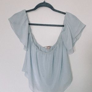 Light-blue, off the shoulder shirt.